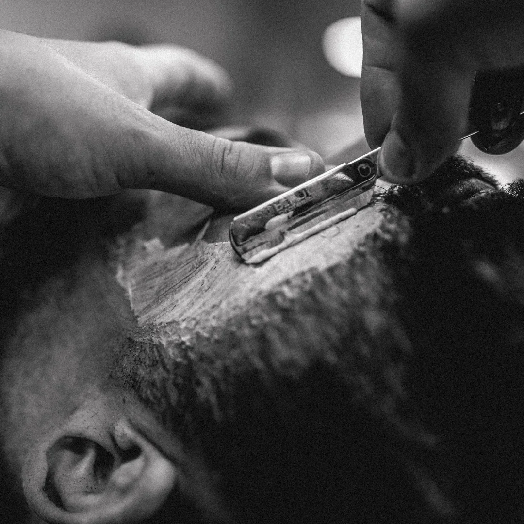 Projeto Le Beard da Nhdesign: Funcionário a barbear a barba de um homem