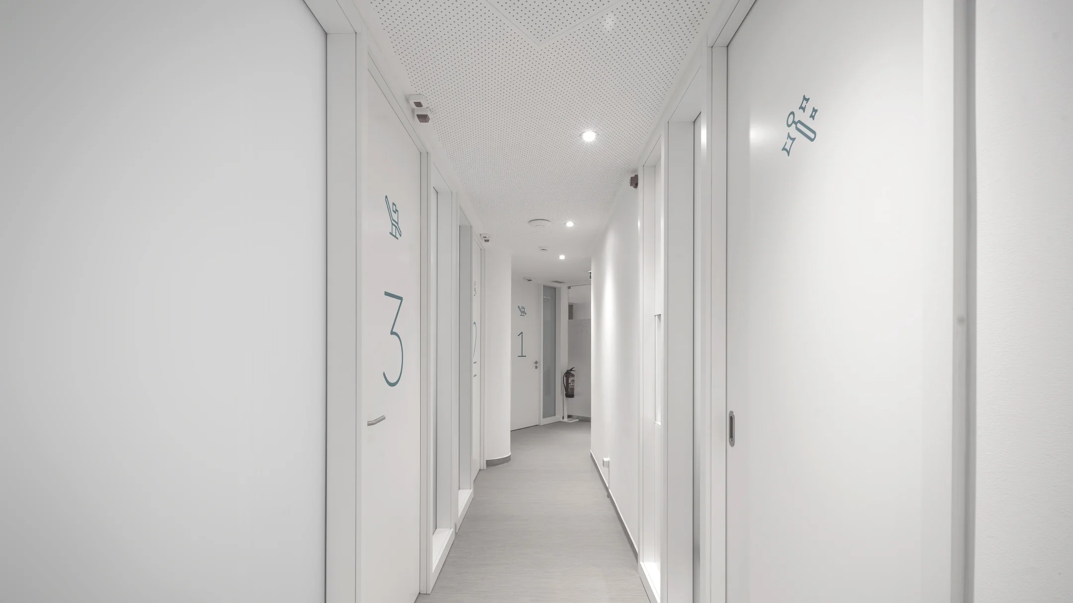 Projeto OCEANUS da Nhdesign: Corredor interior da clínica Oceanus Oral Center em tons brancos