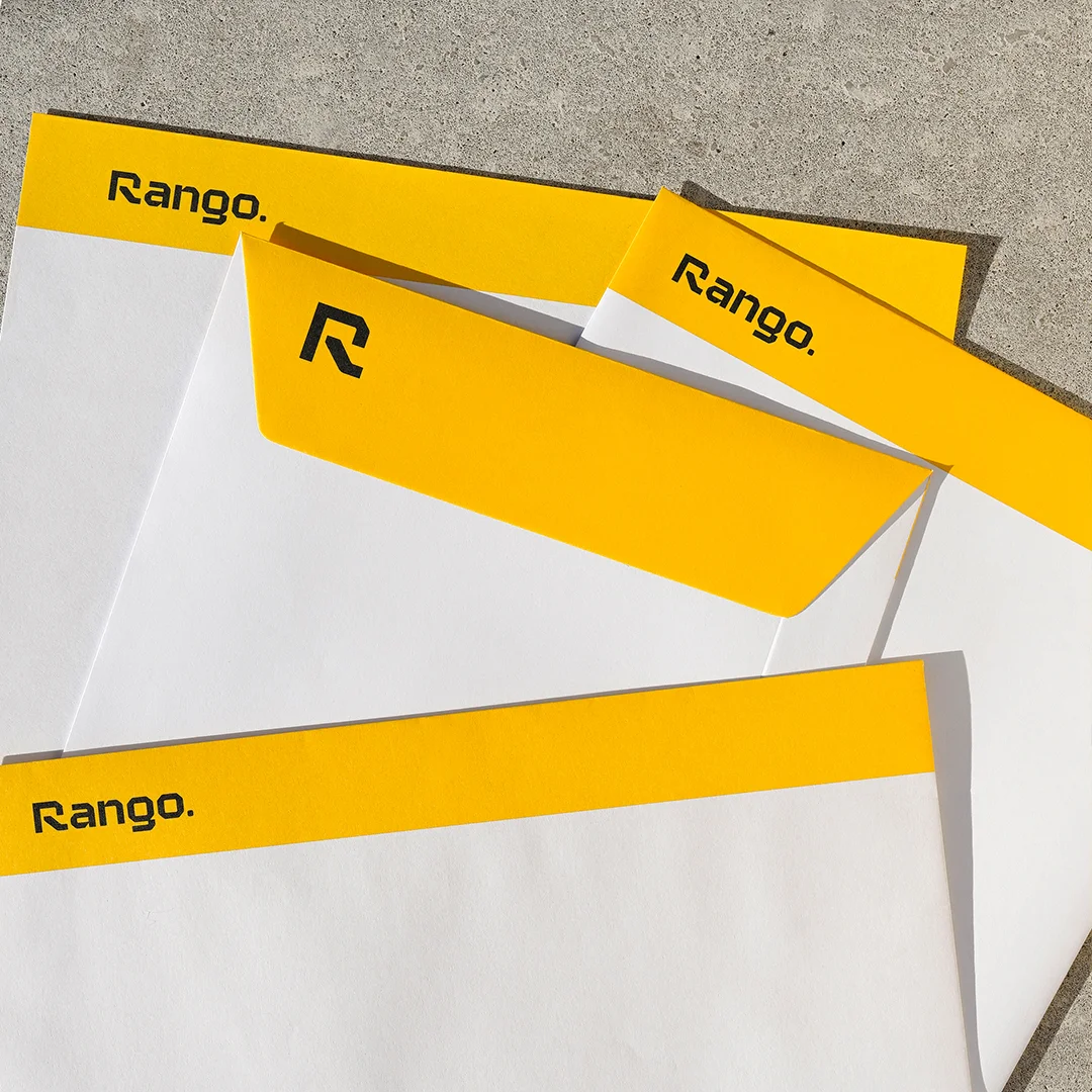 Projeto Rango da Nhdesign: Fotografia dos envelopes da Rango sobre chão de cimento.
